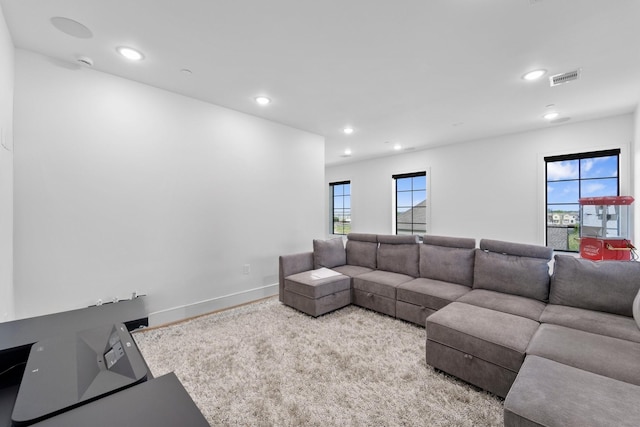 carpeted living area with visible vents and recessed lighting