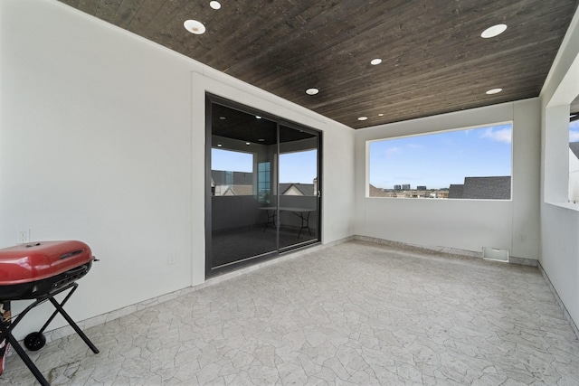 spare room with recessed lighting, wood ceiling, and stone floors