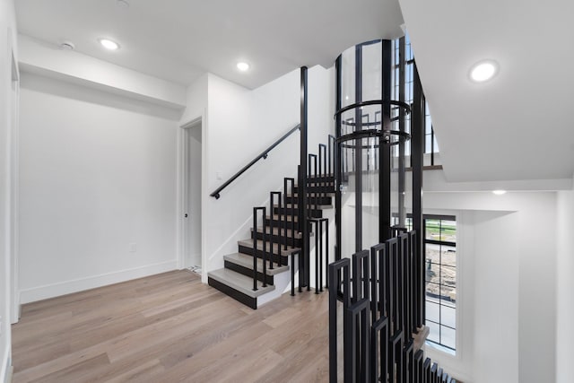 stairs with recessed lighting, baseboards, and wood finished floors