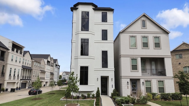 view of front of property featuring a residential view, a front yard, and stucco siding