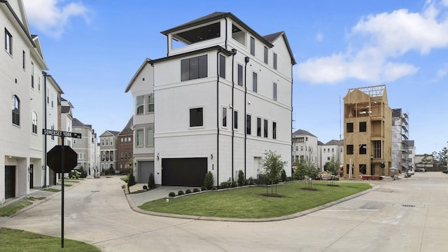 view of building exterior with a garage, concrete driveway, and a residential view