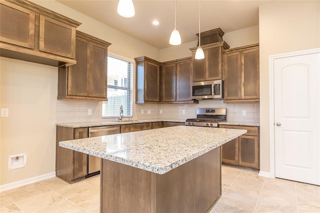 5546 Sallow Bay Ln, Fulshear, TX 77441 - kitchen with stainless steel appliances, a center island, decorative backsplash, pendant lighting, and light stone counters