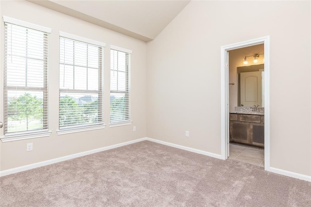 5546 Sallow Bay Ln, Fulshear, TX 77441 - unfurnished bedroom featuring lofted ceiling, baseboards, connected bathroom, and light colored carpet