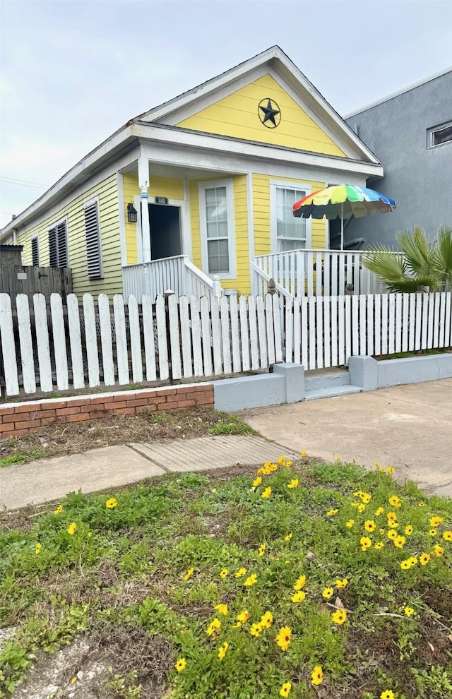 view of front of property featuring fence and covered porch