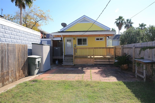 back of house with a patio area, a lawn, and a fenced backyard