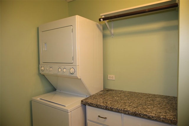 clothes washing area featuring stacked washer and clothes dryer and laundry area