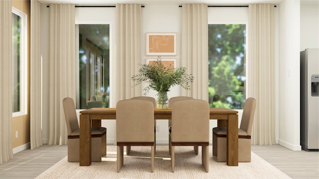 dining area with light wood finished floors, baseboards, and a healthy amount of sunlight