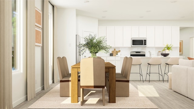 dining space featuring light wood-style flooring