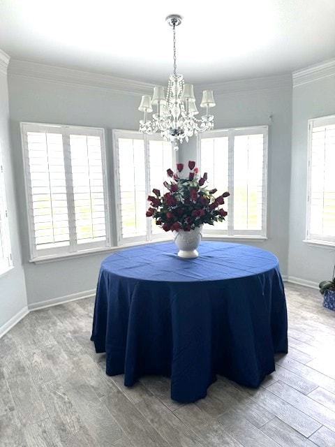 dining room with baseboards, a notable chandelier, ornamental molding, and wood finished floors