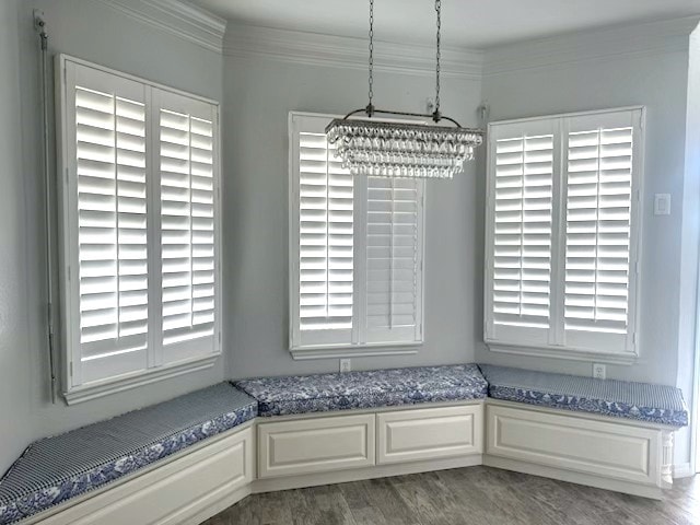 unfurnished dining area with an inviting chandelier, ornamental molding, and wood finished floors