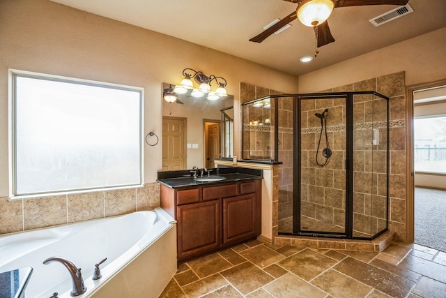 bathroom featuring a stall shower, a bath, vanity, ceiling fan, and visible vents
