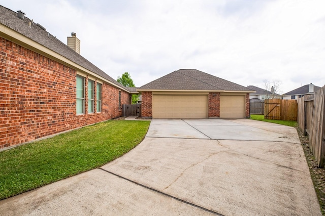 exterior space featuring concrete driveway, a front lawn, brick siding, and fence private yard