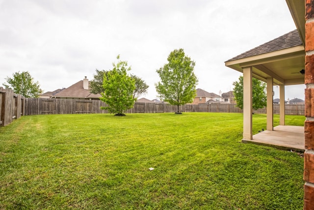 view of yard with a fenced backyard, a ceiling fan, and a patio
