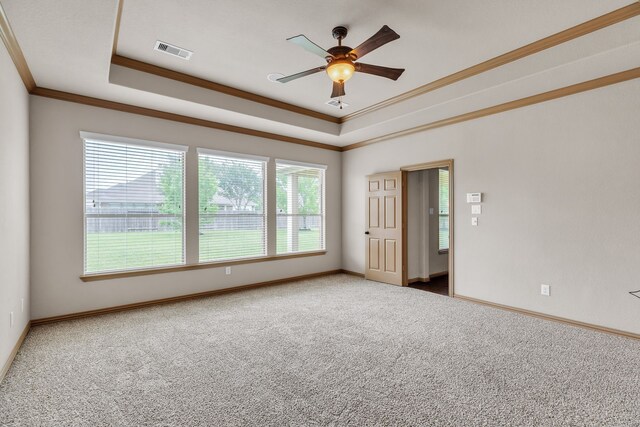 spare room featuring ornamental molding, visible vents, carpet floors, and a raised ceiling