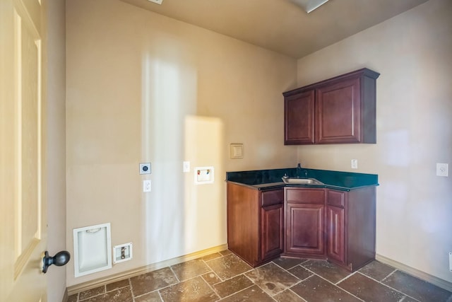 bar featuring stone tile flooring, baseboards, and a sink