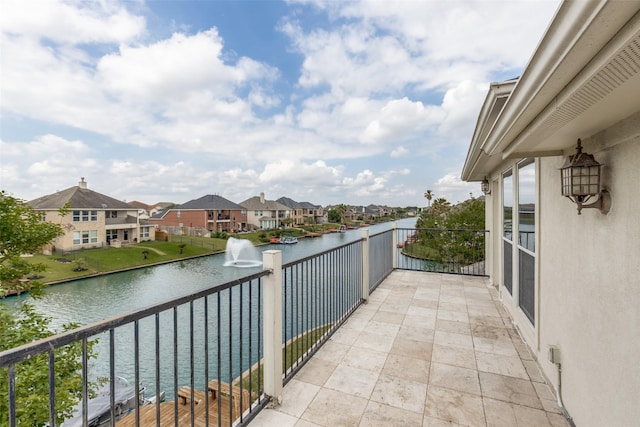 balcony with a residential view and a water view
