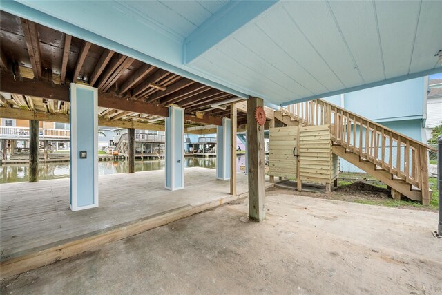 view of patio / terrace with stairs, a water view, a dock, and boat lift