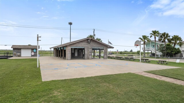 exterior space featuring basketball hoop, fence, and a yard