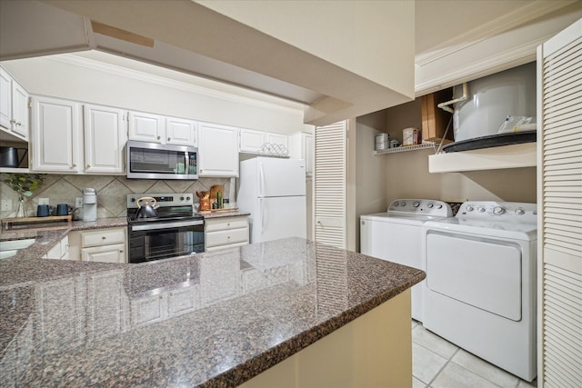 2111 Welch St Unit A219, Houston, TX 77019 - kitchen with crown molding, dark stone counters, stainless steel appliances, and washer and clothes dryer