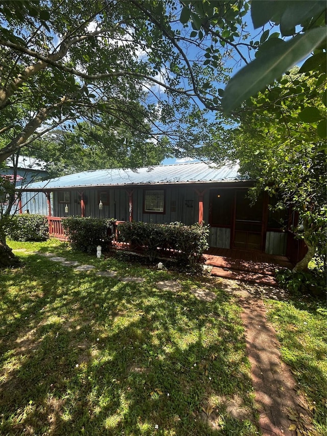 381 Lakeshore Dr, Cleveland, TX 77327 - back of house featuring covered porch, a yard, board and batten siding, and metal roof