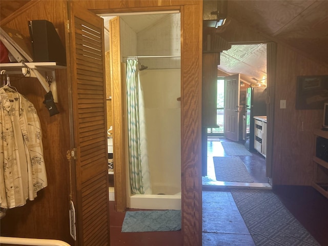 381 Lakeshore Dr, Cleveland, TX 77327 - full bath featuring a shower stall, vaulted ceiling, and wood walls