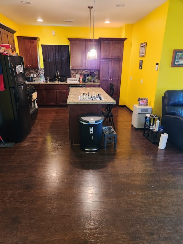 4212 Knoxville St, Houston, TX 77051 - kitchen with a center island, dark wood-style floors, tasteful backsplash, visible vents, and freestanding refrigerator