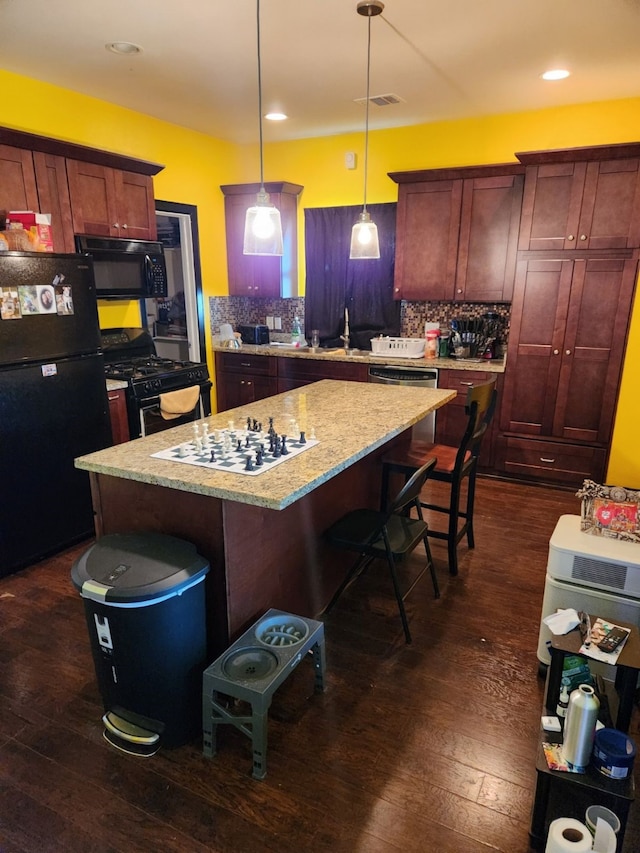 4212 Knoxville St, Houston, TX 77051 - kitchen with black appliances, dark wood-type flooring, visible vents, and a kitchen island