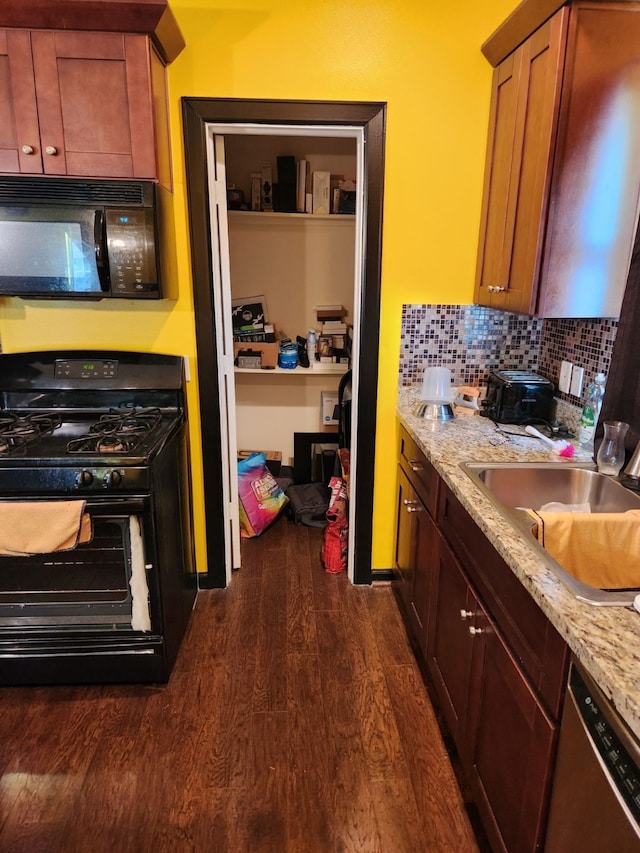 4212 Knoxville St, Houston, TX 77051 - kitchen featuring light stone counters, tasteful backsplash, a sink, black appliances, and dark wood-type flooring