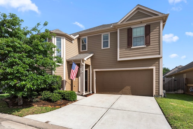 traditional home with concrete driveway, an attached garage, and fence