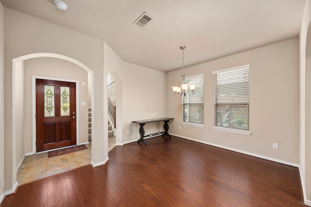 foyer featuring hardwood / wood-style flooring, baseboards, a healthy amount of sunlight, and visible vents