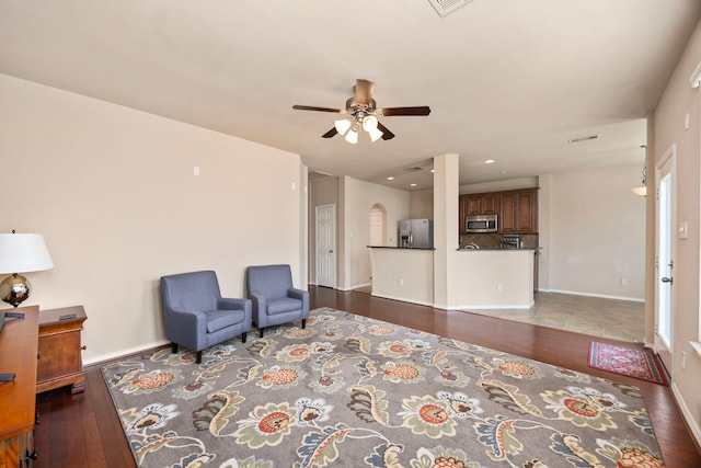 sitting room featuring baseboards, a ceiling fan, and wood finished floors