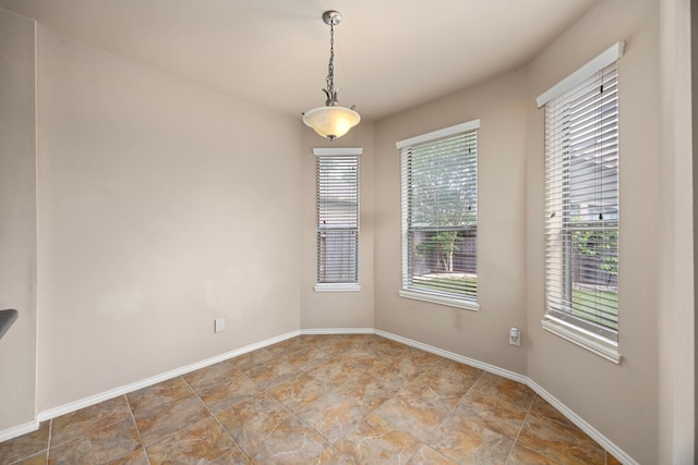 spare room with stone finish floor and baseboards