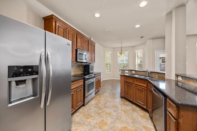 kitchen with brown cabinets, appliances with stainless steel finishes, a sink, and recessed lighting