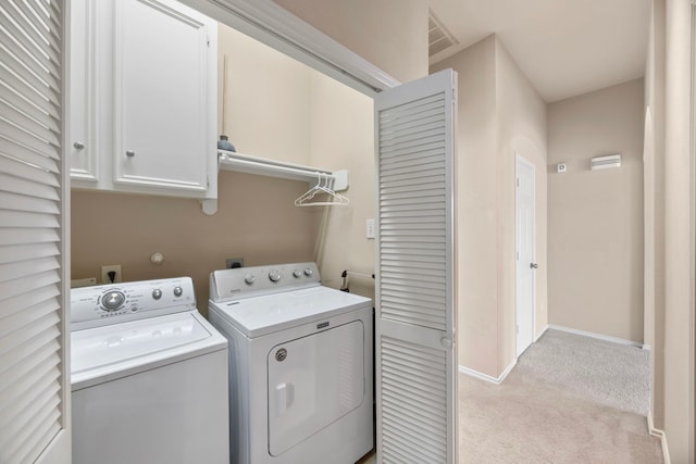 clothes washing area with washer and dryer, light carpet, cabinet space, baseboards, and visible vents
