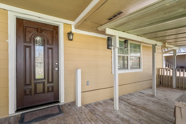 property entrance with covered porch and visible vents