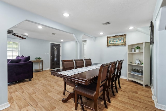 dining space featuring baseboards, visible vents, light wood-style floors, and ceiling fan