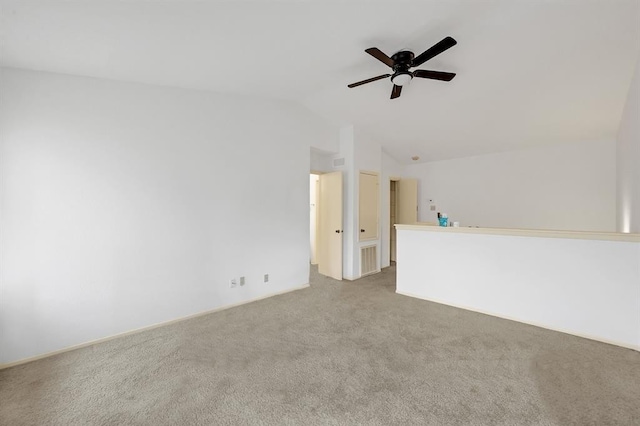empty room with visible vents, vaulted ceiling, carpet flooring, and ceiling fan