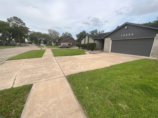 exterior space with brick siding, driveway, a garage, and a front yard