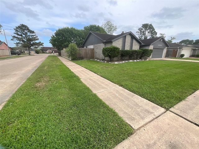 view of side of home featuring a lawn, concrete driveway, fence, a garage, and brick siding