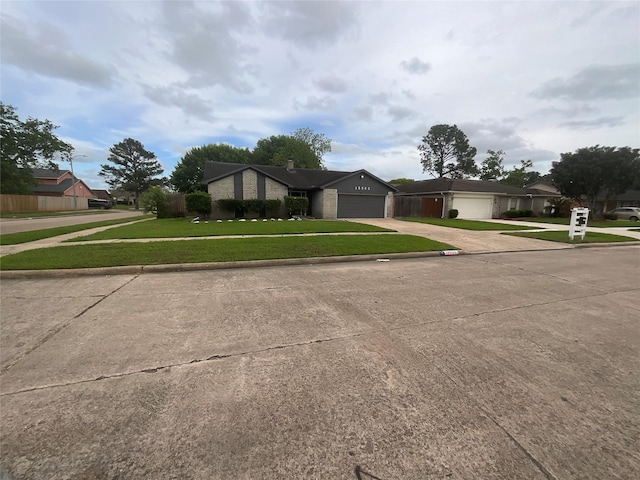 view of front facade with a residential view, an attached garage, driveway, and a front yard