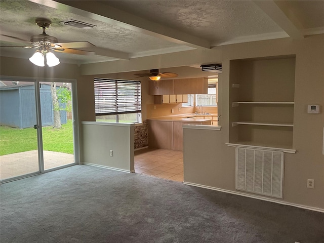 unfurnished living room featuring a textured ceiling, visible vents, and ceiling fan