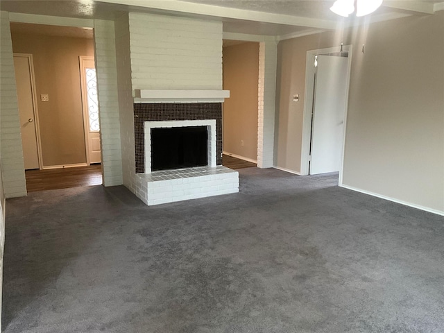 unfurnished living room with dark colored carpet, baseboards, and a fireplace
