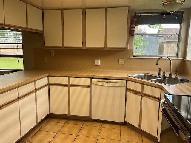 kitchen featuring dishwasher, light countertops, a sink, and light tile patterned floors