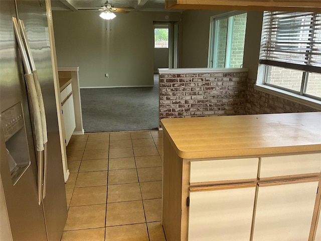 kitchen with stainless steel refrigerator with ice dispenser, light colored carpet, light tile patterned floors, and ceiling fan
