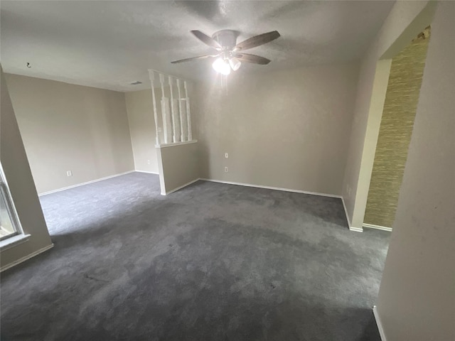 unfurnished room featuring dark carpet, baseboards, and a ceiling fan