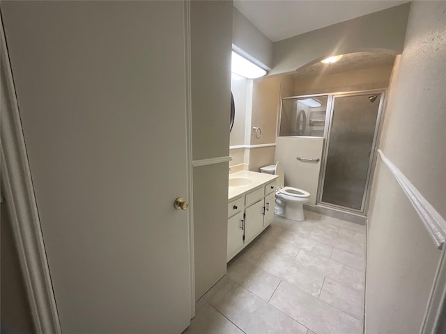 full bath featuring toilet, vanity, tile patterned floors, and a stall shower