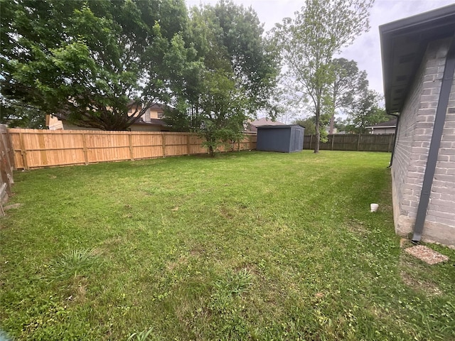 view of yard featuring a fenced backyard, an outbuilding, and a storage shed