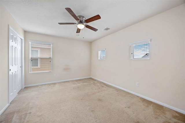 spare room featuring ceiling fan, baseboards, and carpet flooring