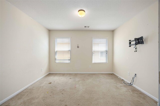 carpeted spare room with baseboards and visible vents