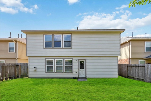 rear view of property with a lawn and a fenced backyard